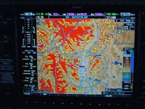 GARMIN 1000 warns for terrain on the approach in to Innsbruck (red areas is terrain that is higher than the airplane)